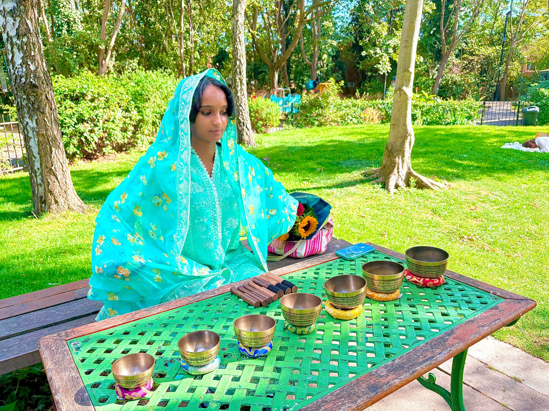 Christiana Queen with singing bowls in a sunlit park